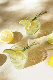 Glasses of summer refreshing lemonade and ingredients on light table