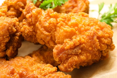 Photo of Tasty deep fried chicken pieces served on table, closeup