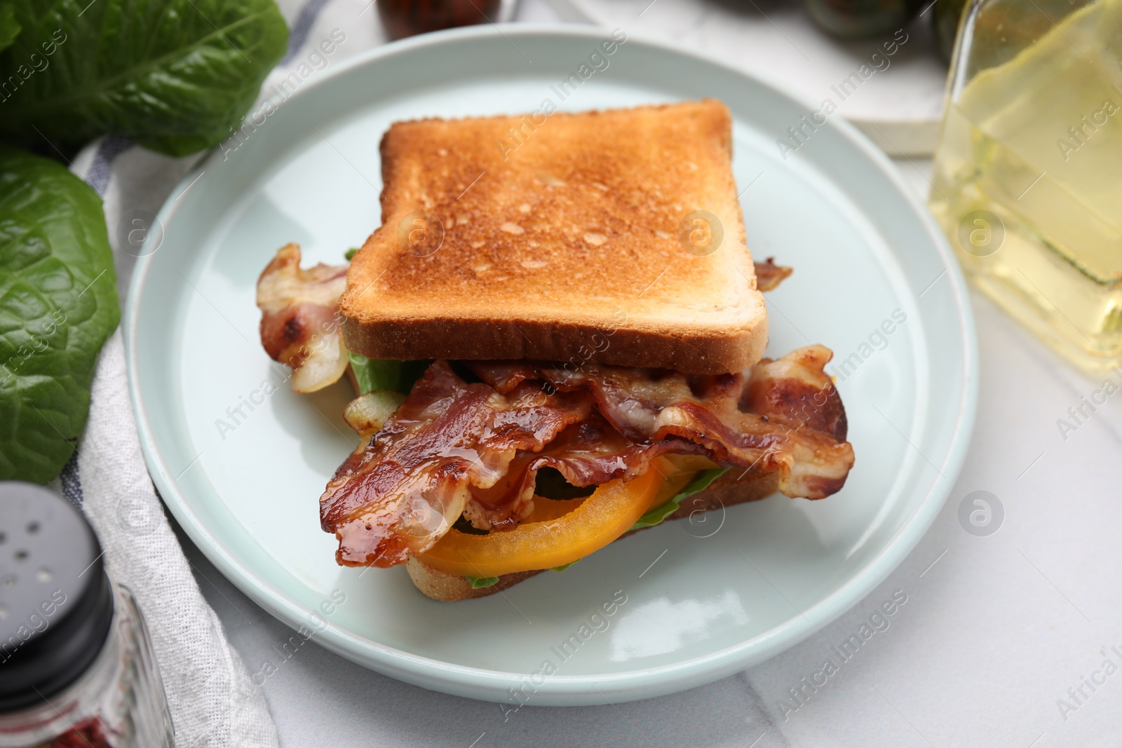 Photo of Tasty sandwich with bacon and bell pepper on white table