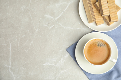 Breakfast with delicious wafers and coffee on grey marble table, flat lay. Space for text