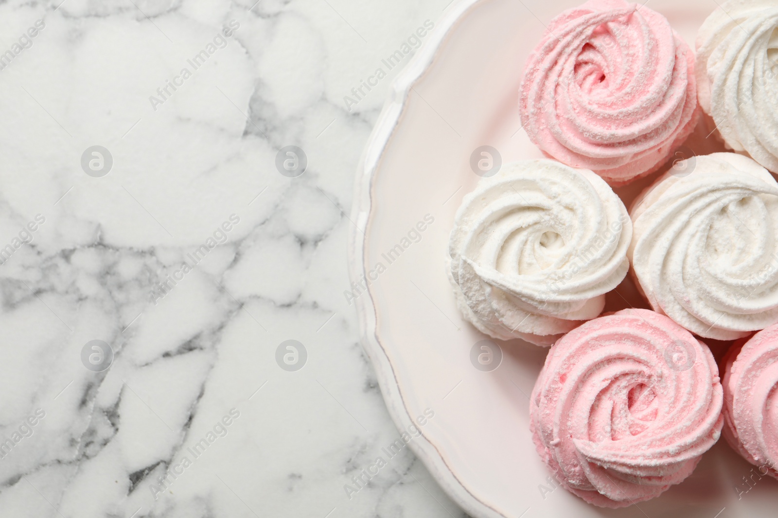 Photo of Delicious marshmallows on white marble table, top view. Space for text