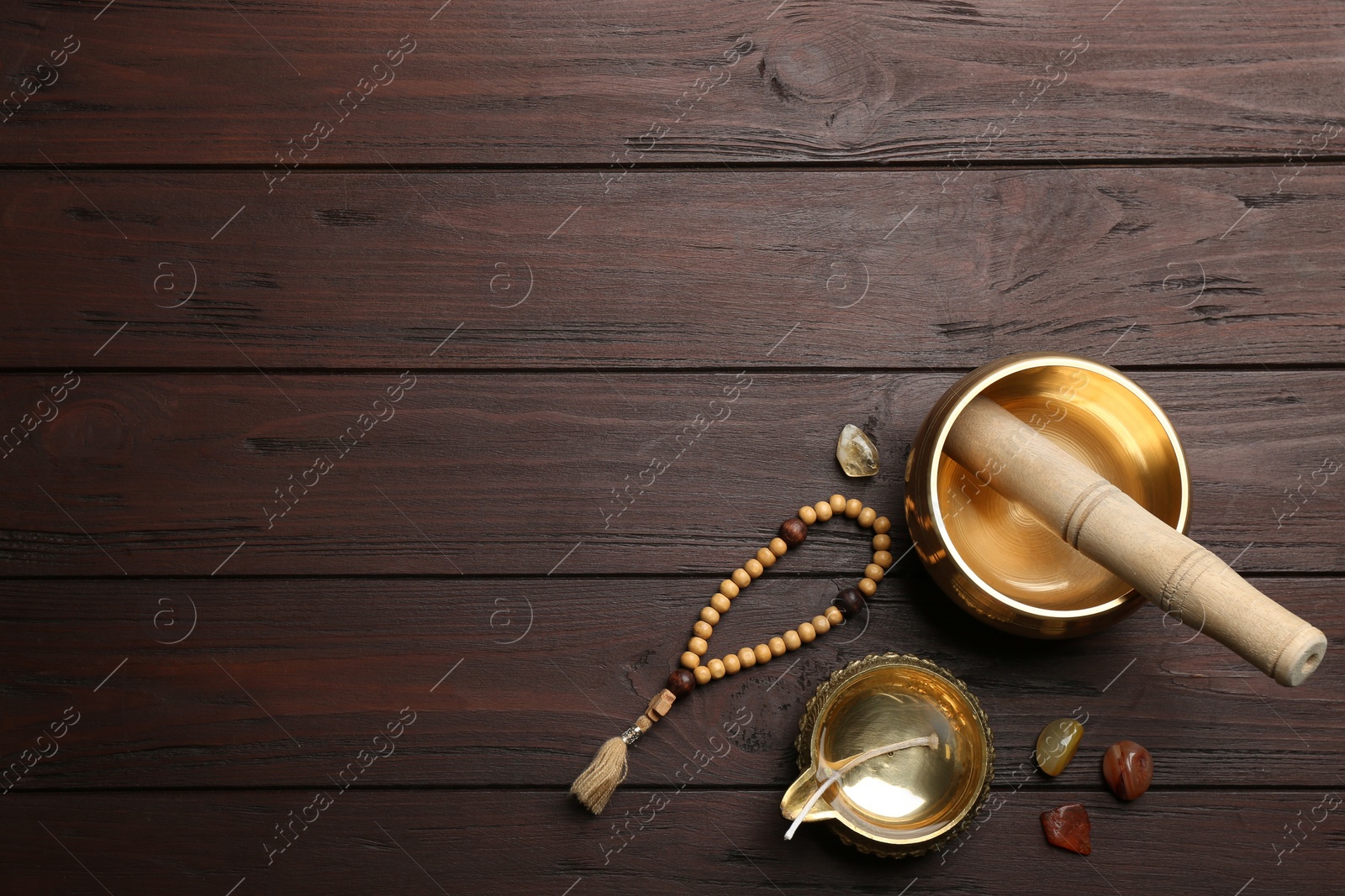 Photo of Flat lay composition with golden singing bowl on wooden table, space for text. Sound healing