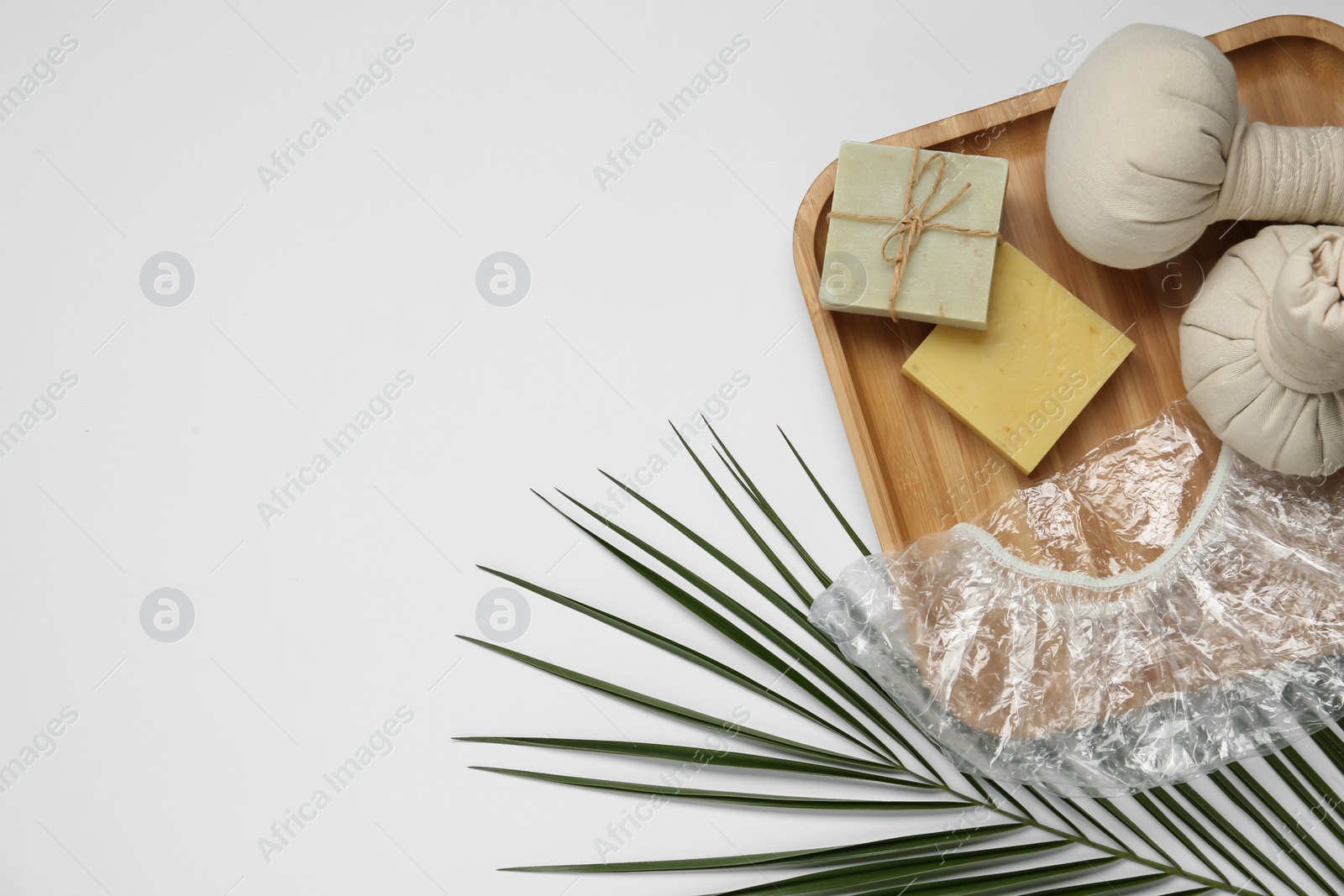 Photo of Flat lay composition with shower cap and toiletries on white background. Space for text