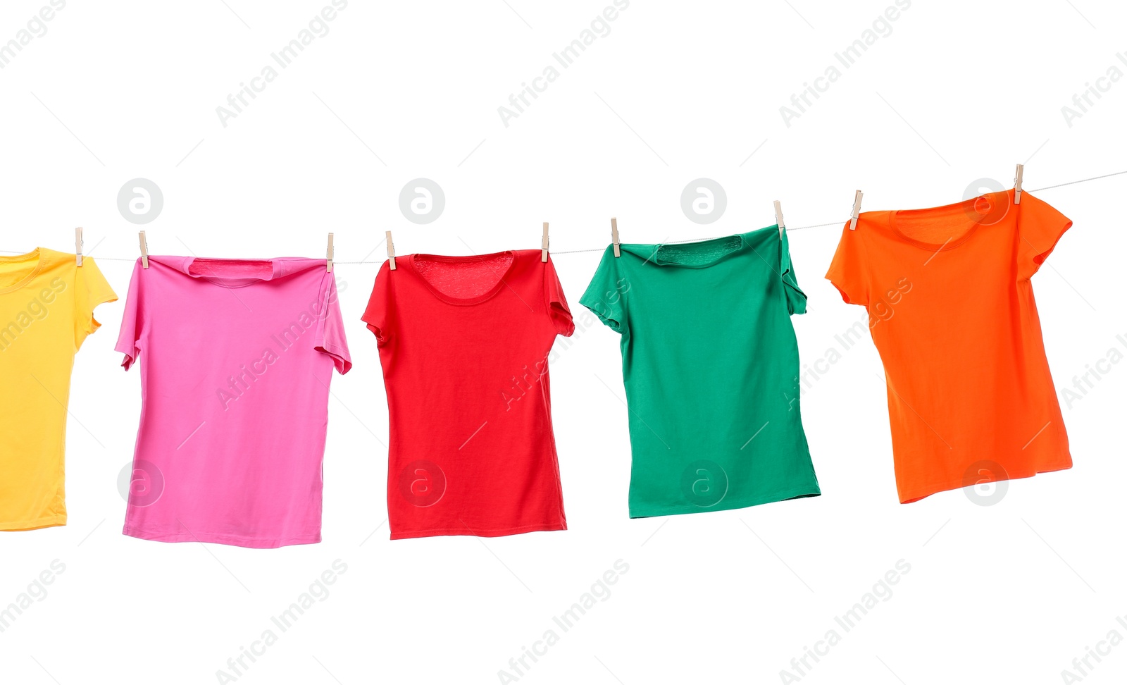 Photo of Different bright t-shirts drying on washing line against white background