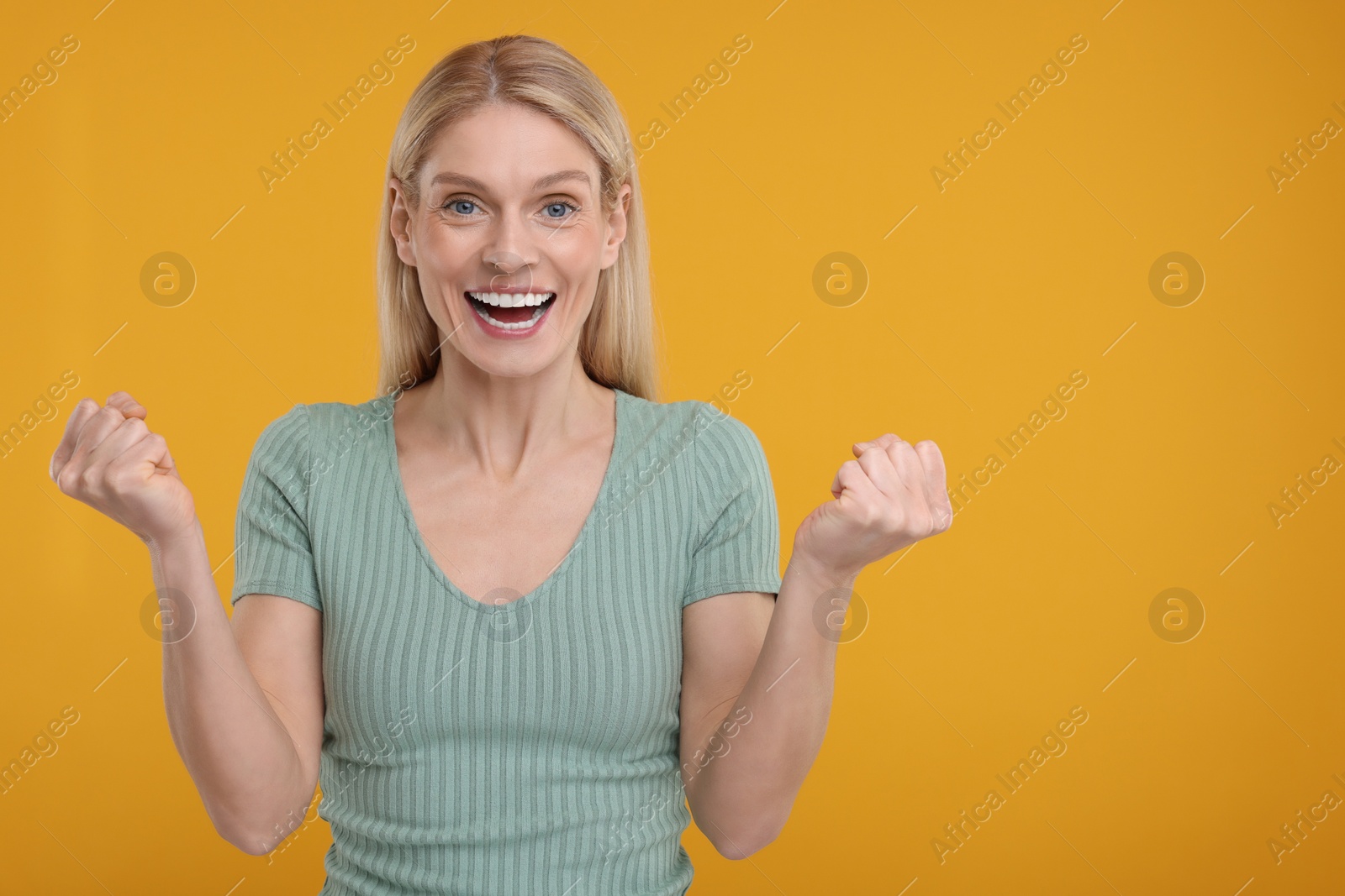 Photo of Portrait of surprised woman on yellow background, space for text