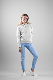 Photo of Full length portrait of woman in hoodie sweater on light background. Space for design