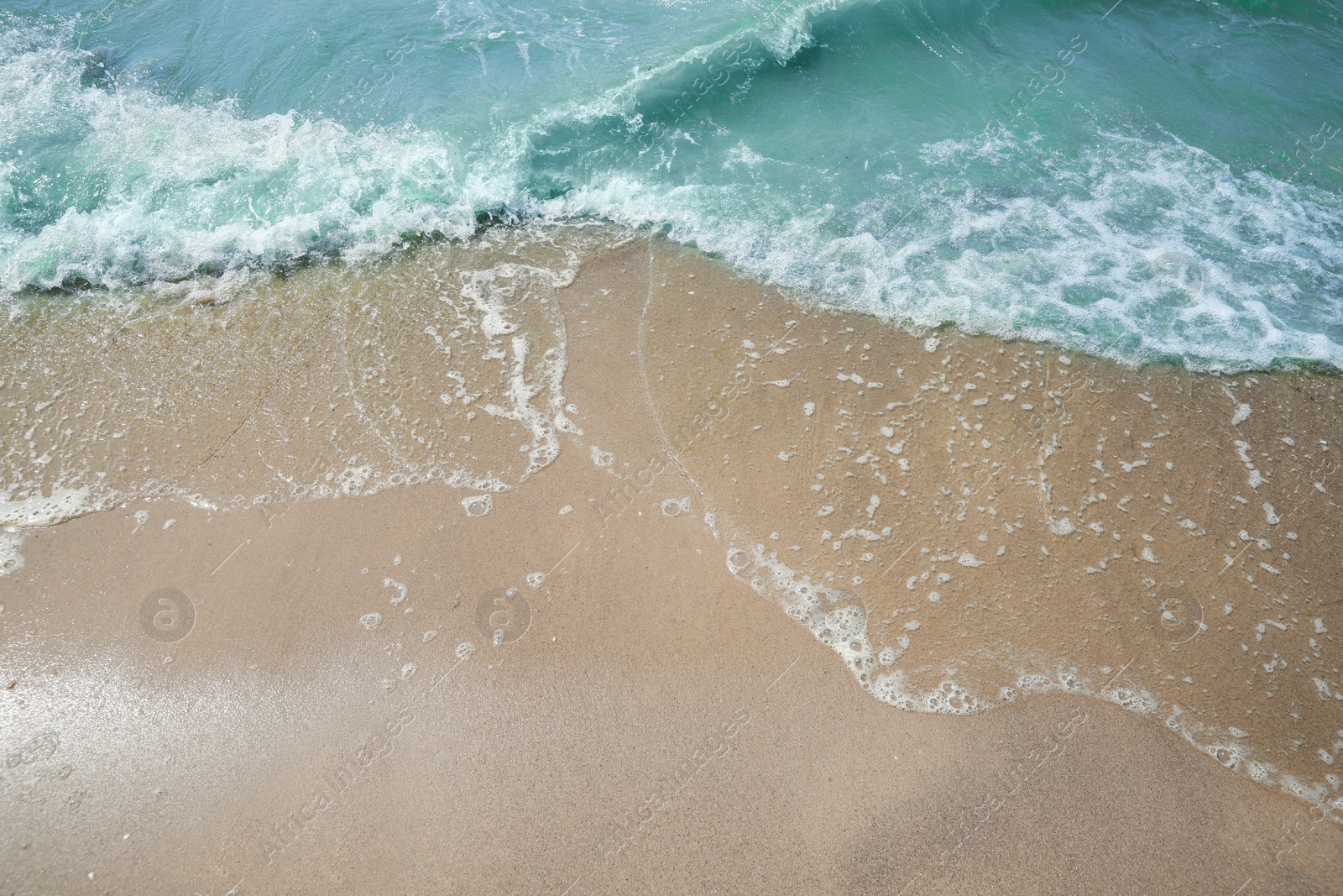 Photo of Tropical sandy beach washed by sea on sunny day