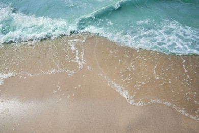 Photo of Tropical sandy beach washed by sea on sunny day