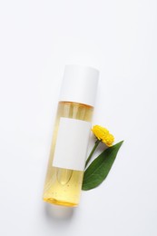 Bottle of cosmetic product and beautiful flower on white background, flat lay