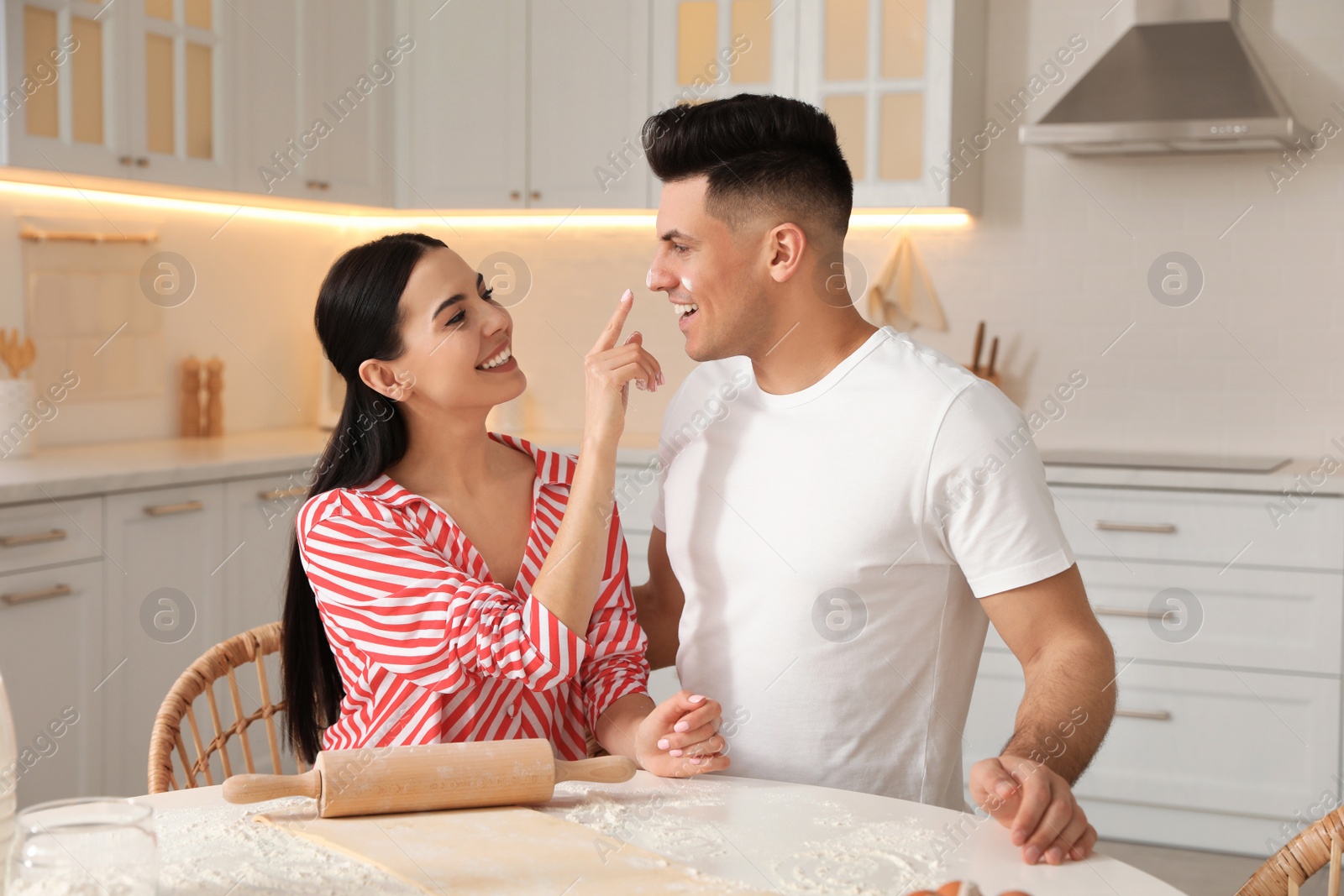 Photo of Happy couple wearing pyjamas and cooking together in kitchen