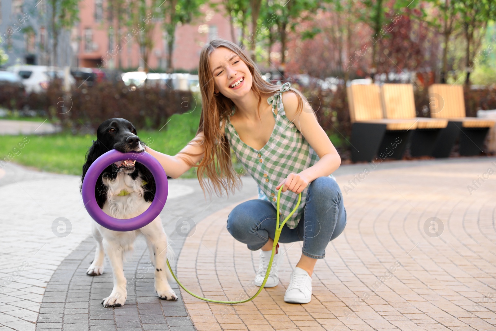 Photo of Young woman with her English Springer Spaniel dog outdoors