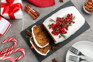 Photo of Flat lay composition with traditional classic Christmas cake with cranberries, pomegranate seeds and rosemary on table