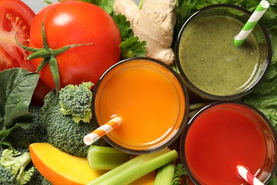 Delicious vegetable juices and fresh ingredients as background, top view