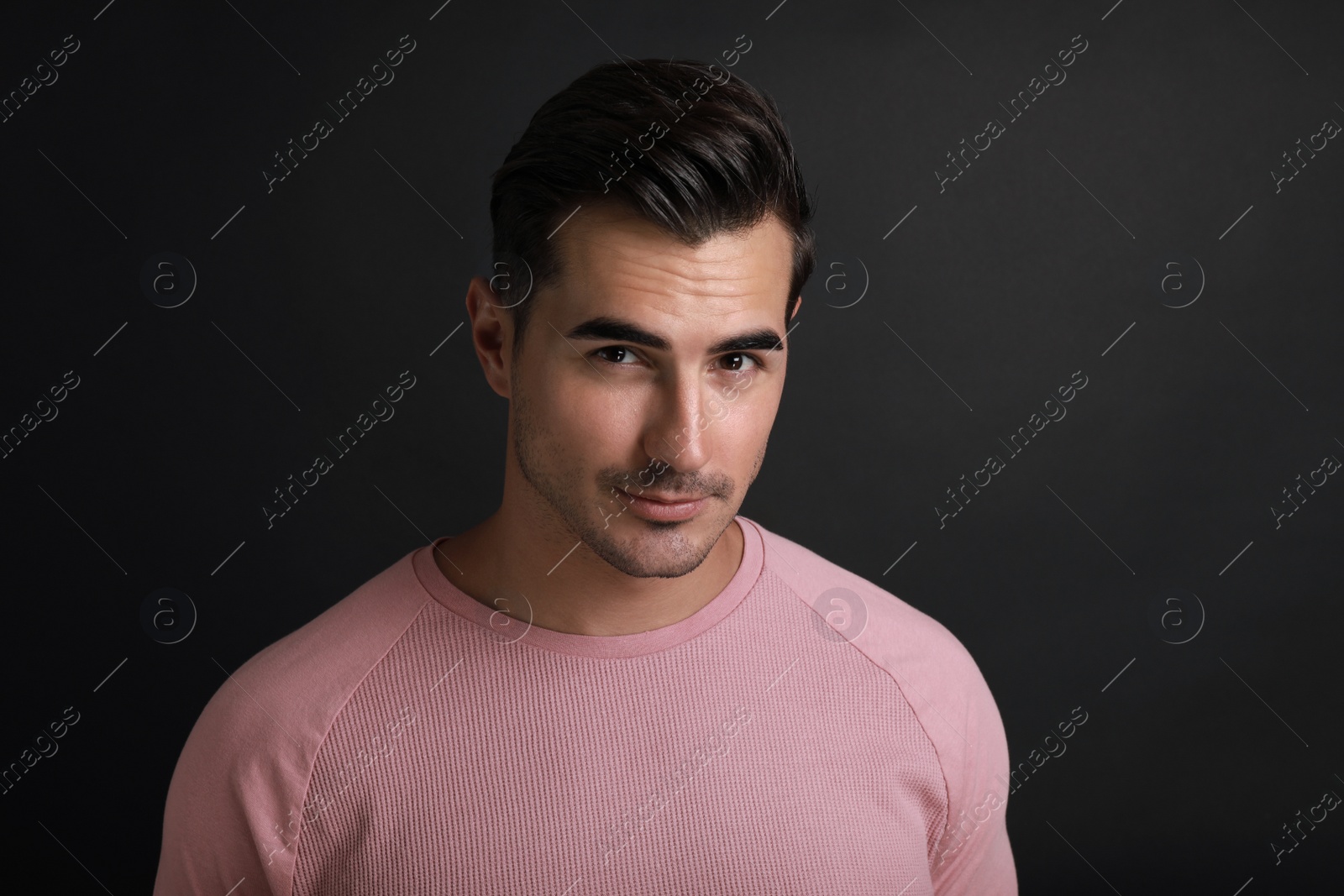 Photo of Portrait of handsome young man on black background