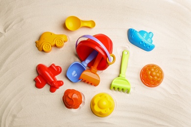 Photo of Flat lay composition with colorful beach toys on sand