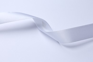 Photo of One beautiful silk ribbon on white background