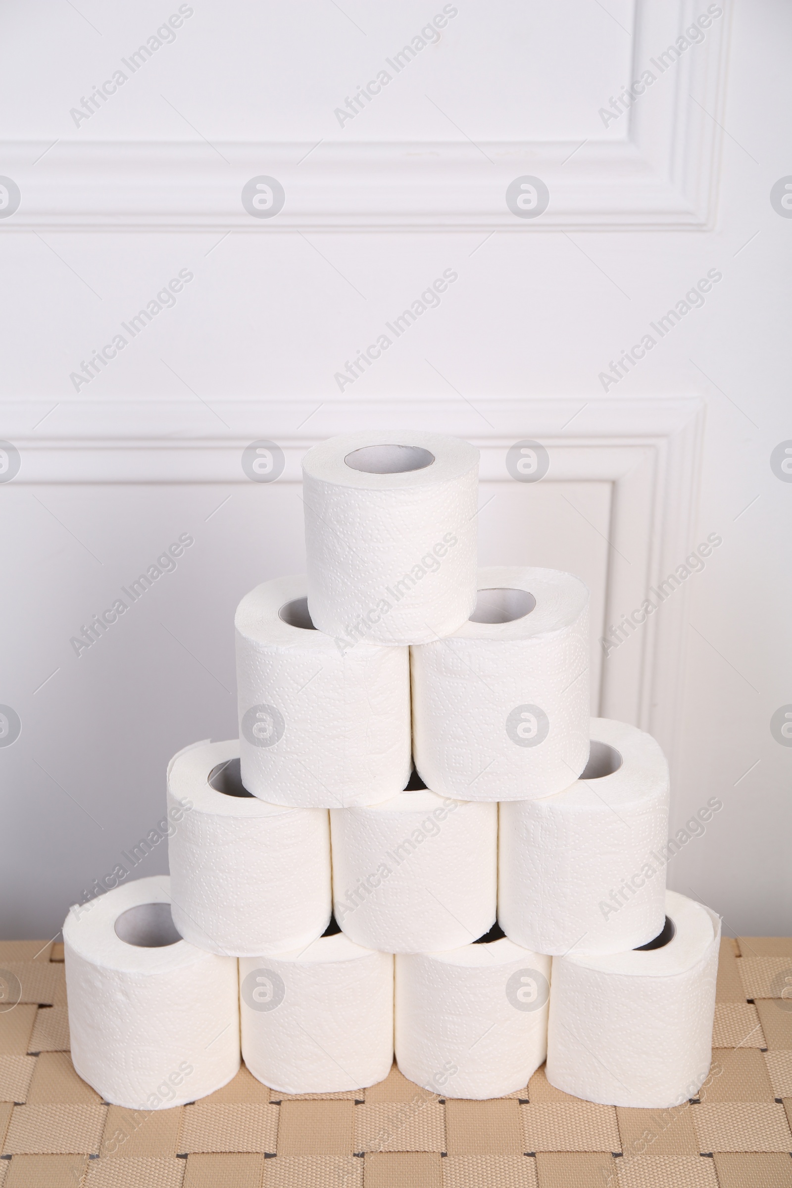 Photo of Pyramid of toilet paper rolls on wicker table