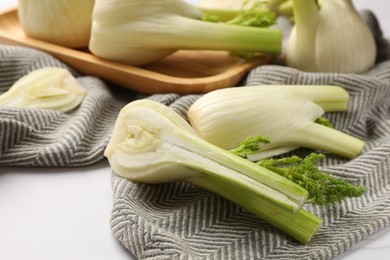 Photo of Whole and cut fennel bulbs on white table, closeup