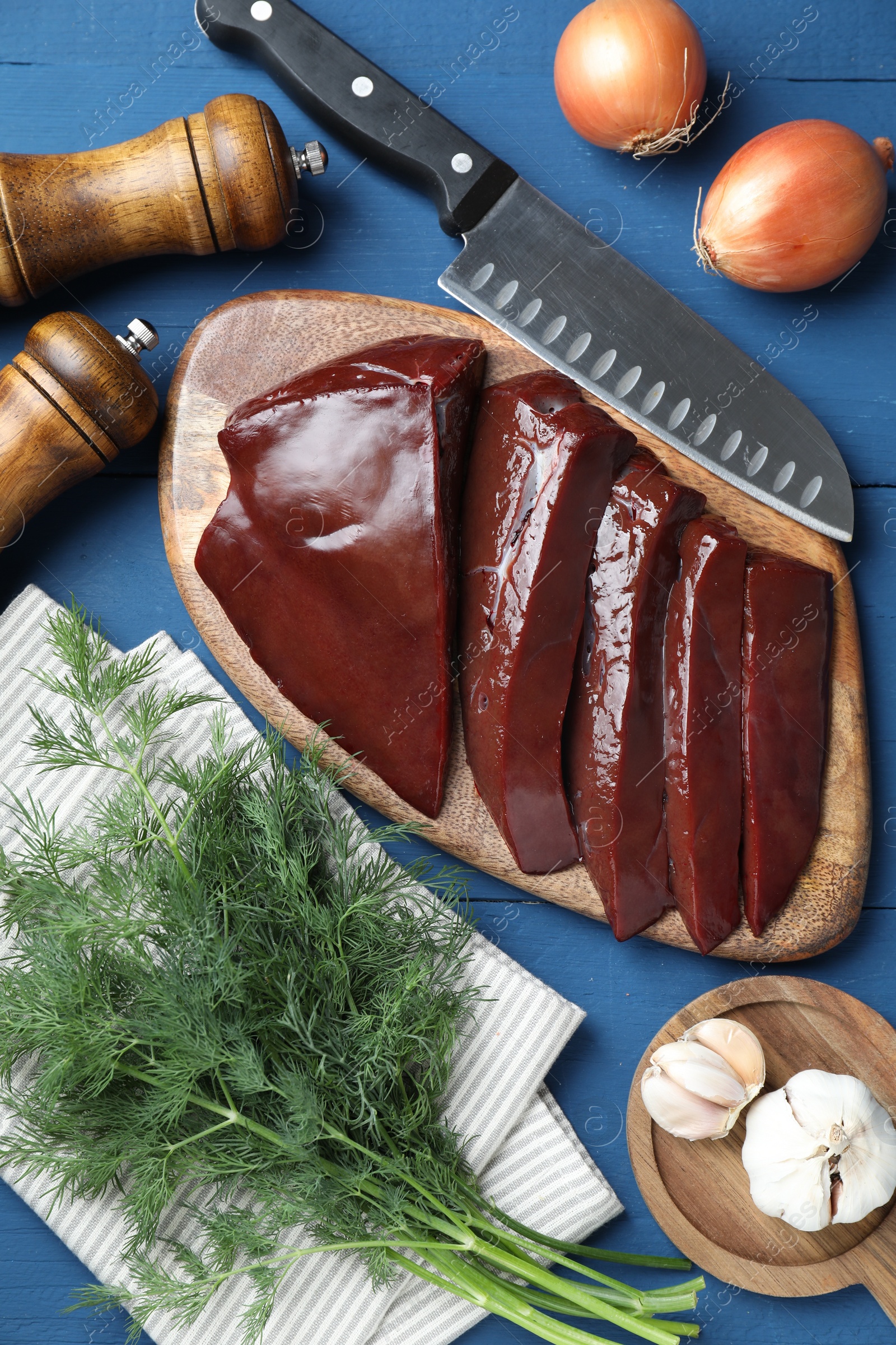 Photo of Flat lay composition with cut raw beef liver on blue wooden table