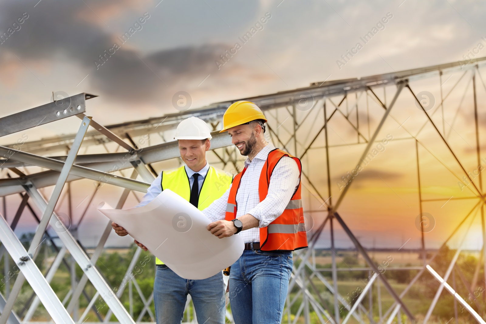 Photo of Professional engineers working on installation of electrical substation outdoors