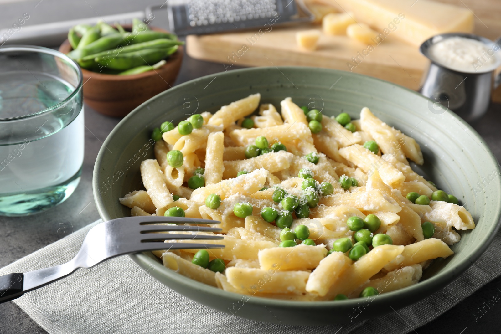 Photo of Delicious pasta with green peas served on table, closeup