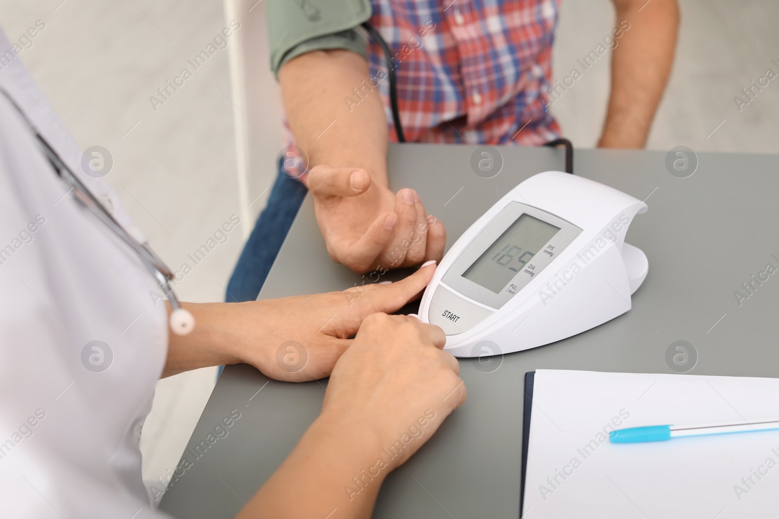 Photo of Doctor checking patient's blood pressure in hospital