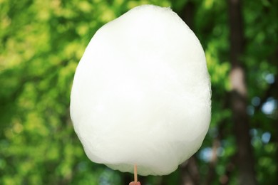 Woman holding sweet cotton candy outdoors, closeup
