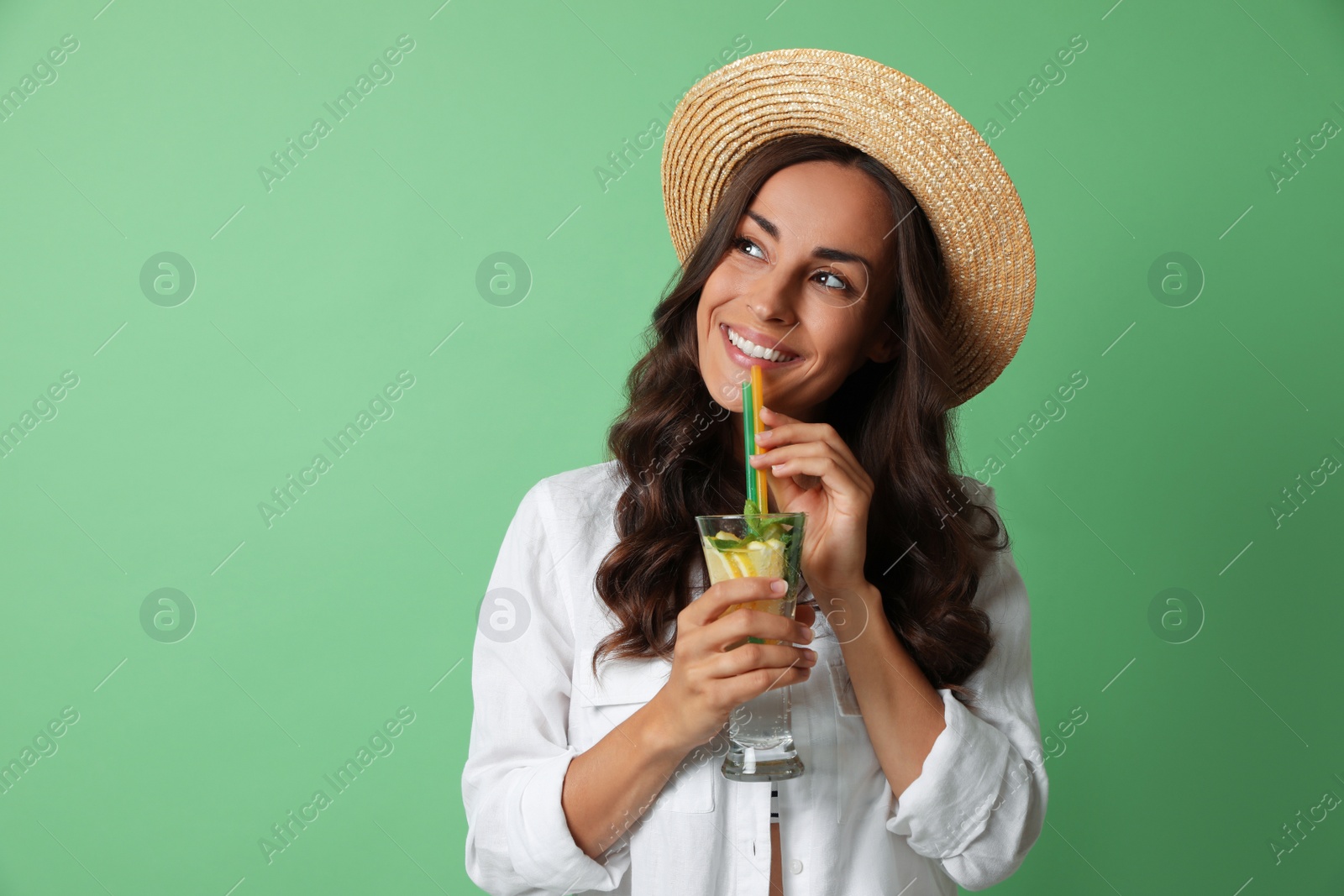 Photo of Young woman with refreshing drink on green background. Space for text