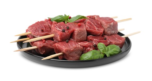 Wooden skewers with cut fresh beef meat, basil leaves and spices isolated on white