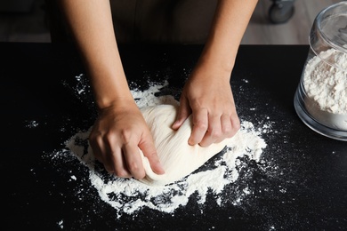 Woman kneading dough for pastry on table