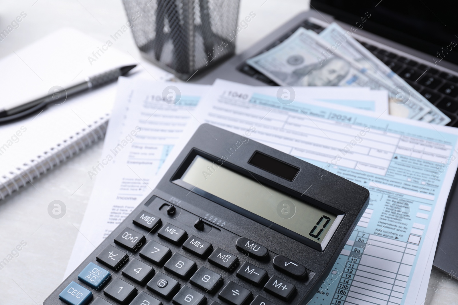 Photo of Tax accounting. Calculator, documents, money and stationery on light grey table, closeup