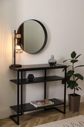 Console table with decor and mirror on white wall in hallway. Interior design