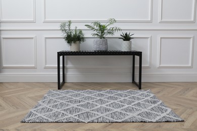 Bench with houseplants and rug on room. Interior accessory