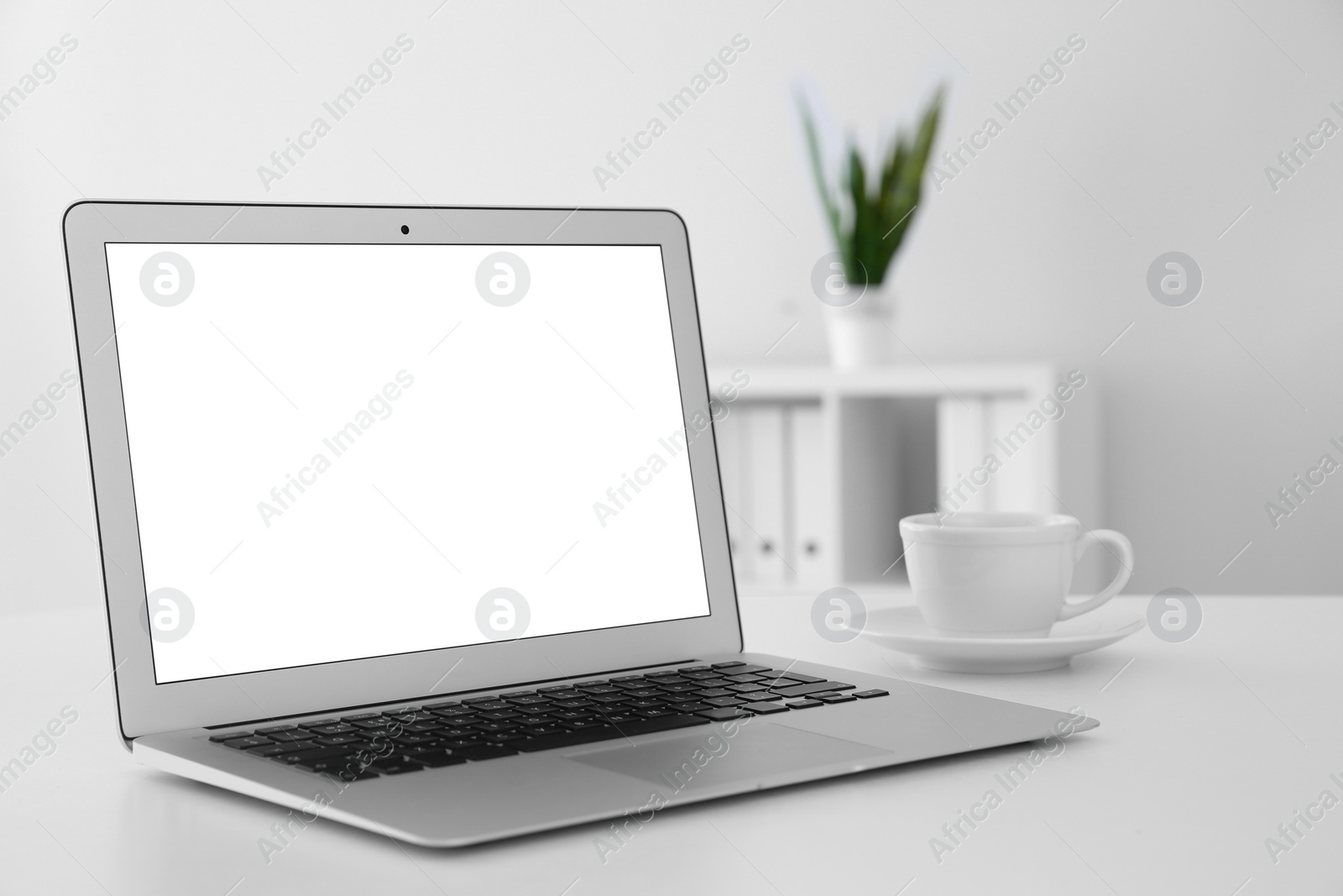 Photo of Comfortable workplace with modern laptop on table in office. Mockup for design