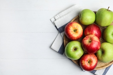 Different sweet apples on white wooden table, top view. Space for text