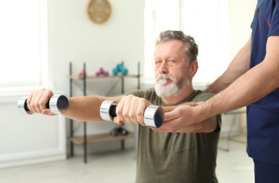 Photo of Physiotherapist working with patient in clinic. Rehabilitation therapy