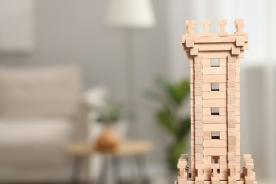 Photo of Wooden tower against blurred background, closeup. Space for text. Children's toy