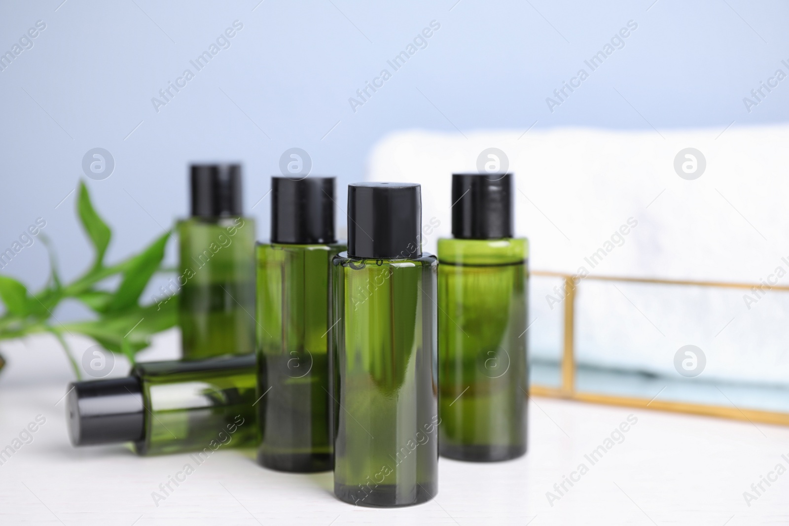 Photo of Mini bottles with cosmetic products on white table