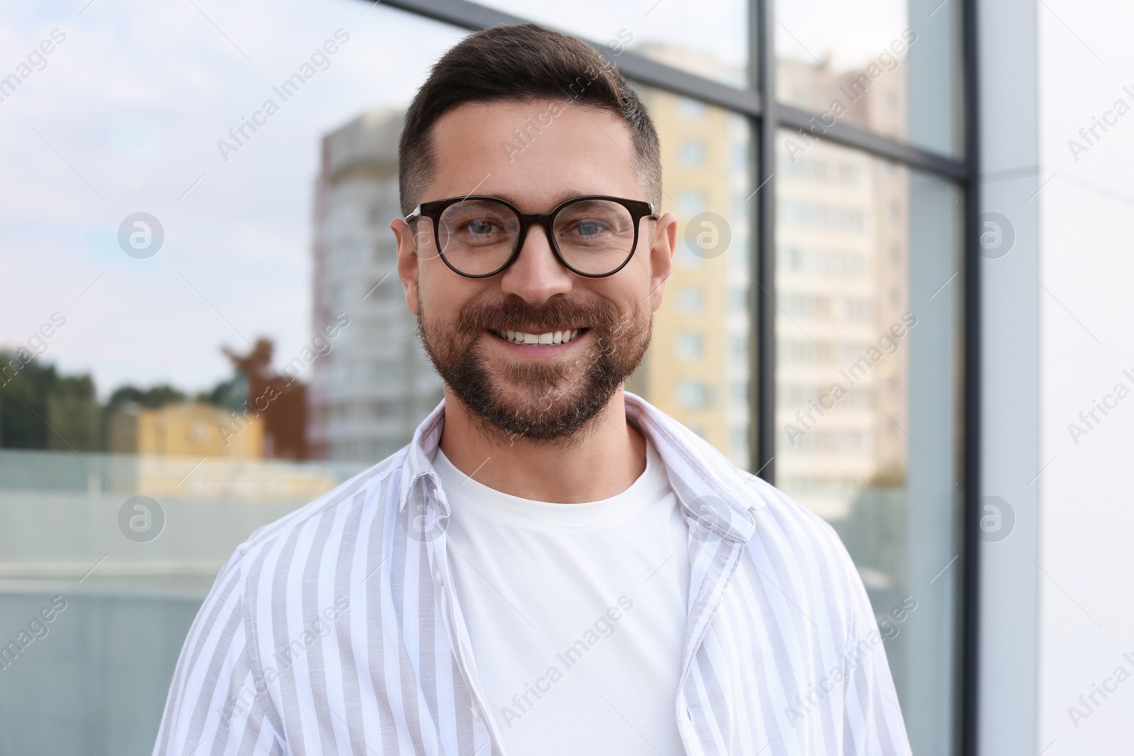 Photo of Portrait of handsome bearded man in glasses outdoors