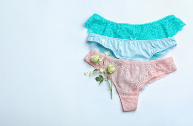 Photo of Set of elegant women's underwear and flowers on white background, flat lay