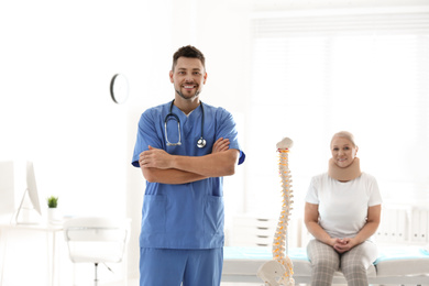 Photo of Male orthopedist and patient with injured neck in clinic