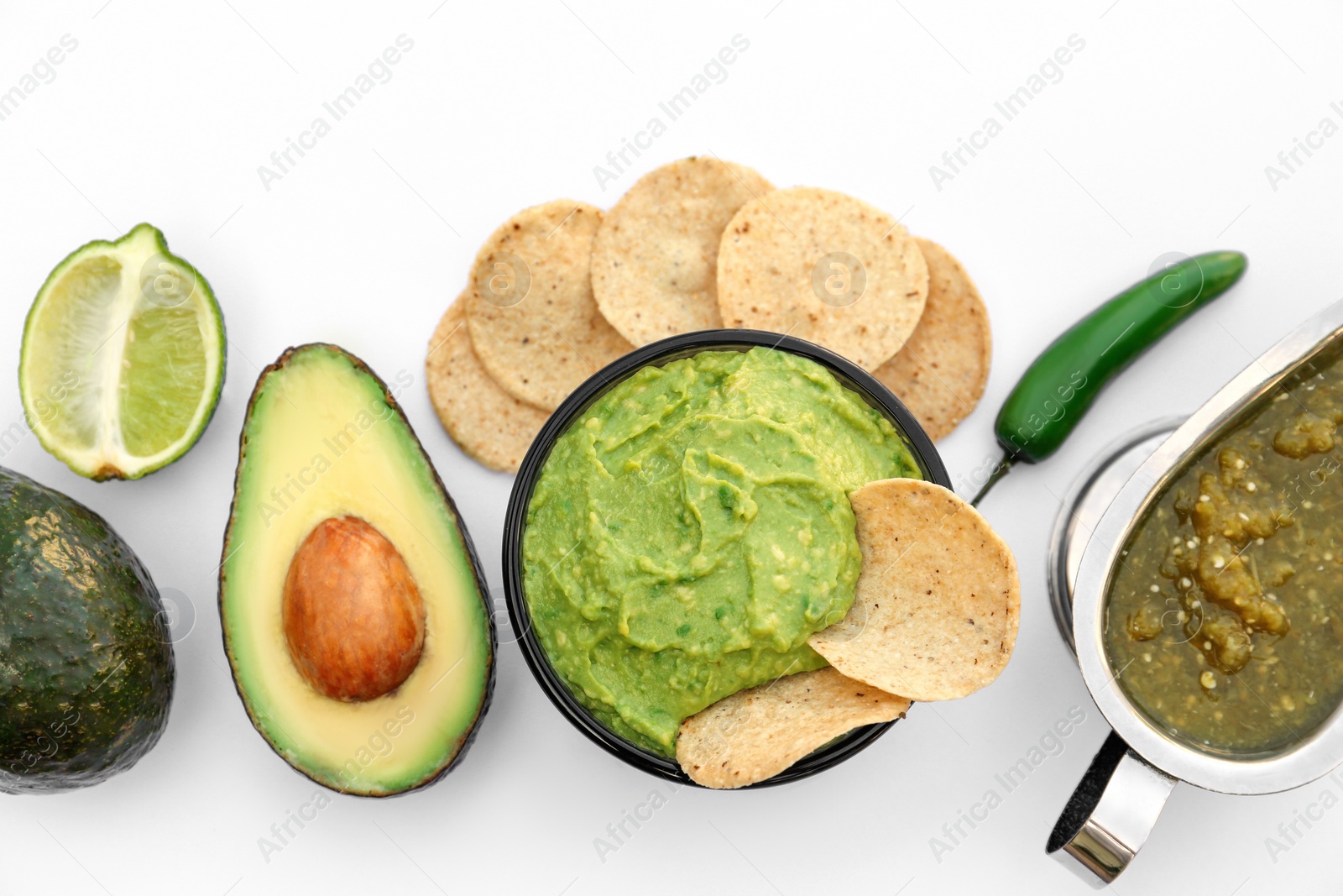 Photo of Delicious guacamole made of avocados, nachos and green pepper on white background, top view
