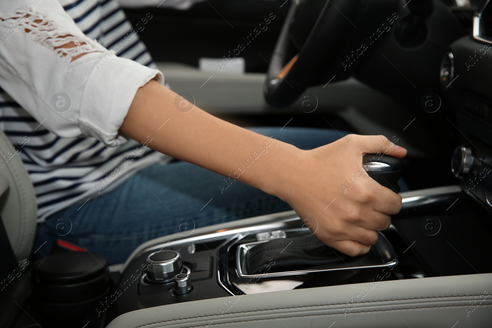 Photo of Woman shifting gears in car, closeup. Driving license test