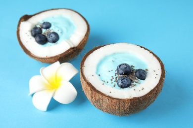 Photo of Coconuts with yummy spirulina smoothie on color background, closeup