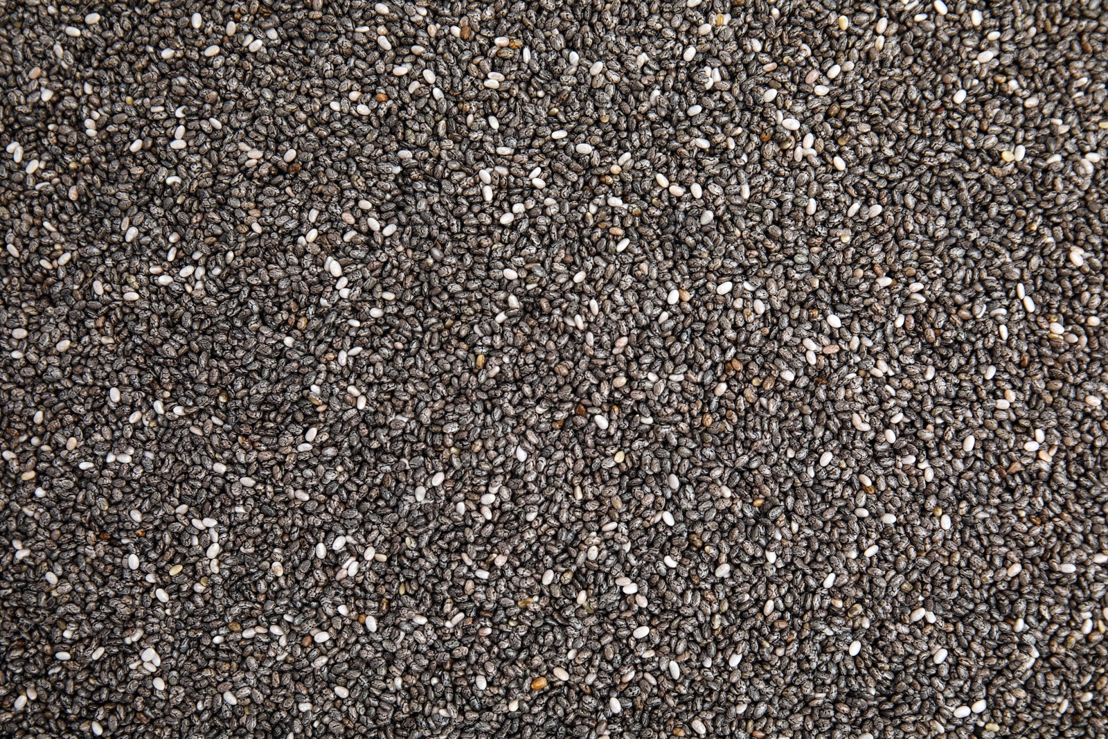 Photo of Heap of chia seeds as background, top view. Veggie food