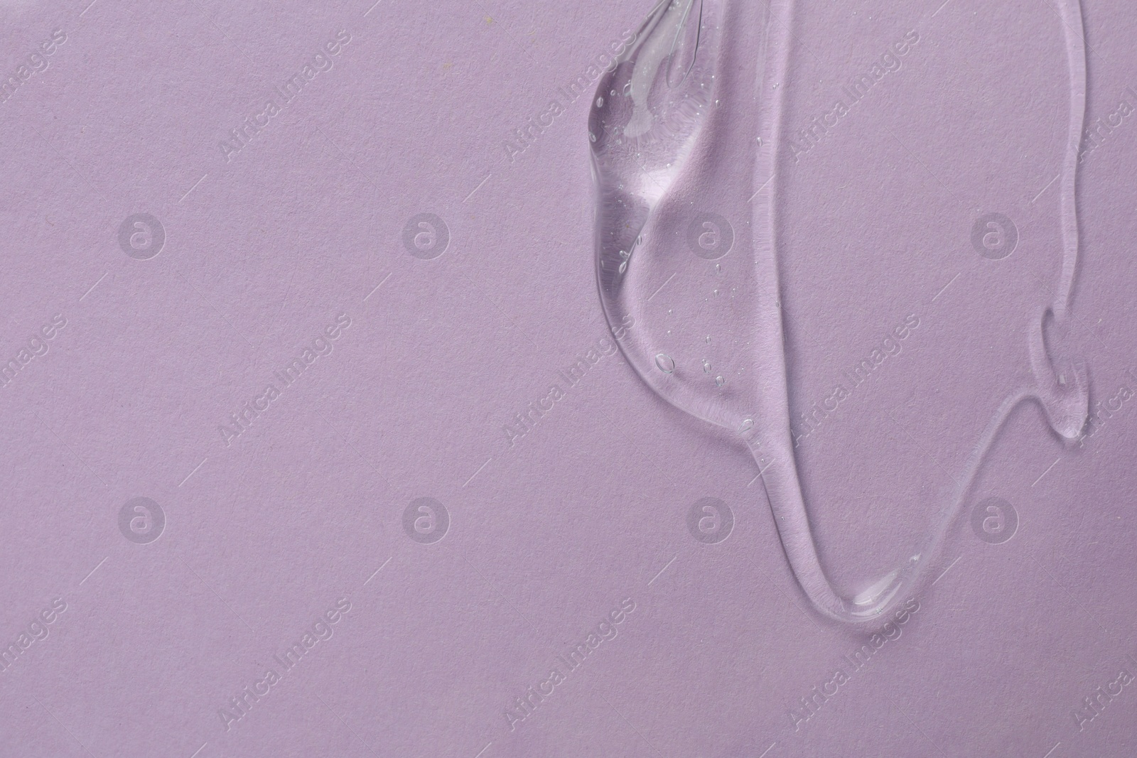 Photo of Clear cosmetic gel on light violet background, top view. Space for text