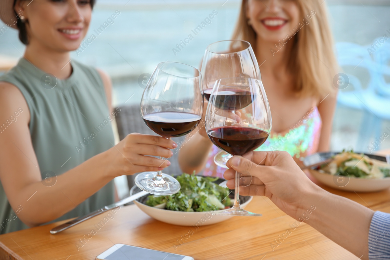 Photo of Group of friends with glasses of wine at table