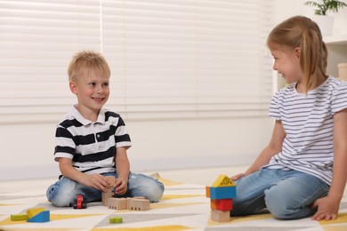 Photo of Little children playing with building blocks indoors. Wooden toys