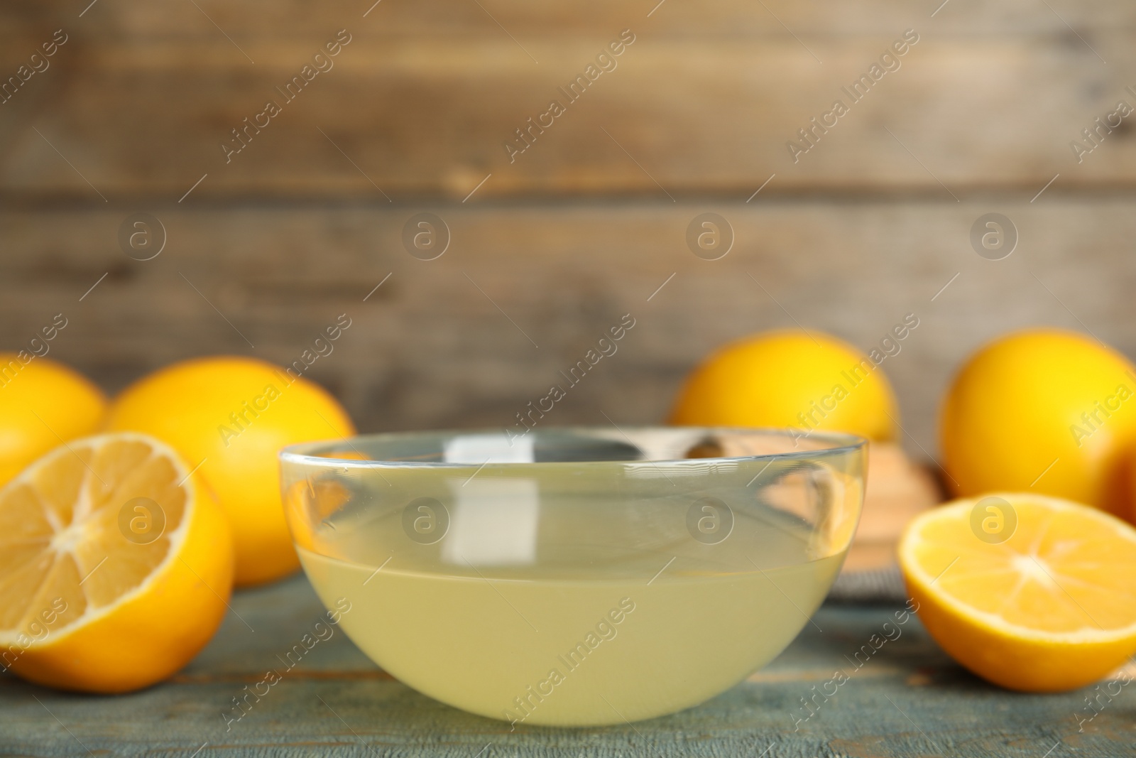 Photo of Freshly squeezed lemon juice in glass bowl on table