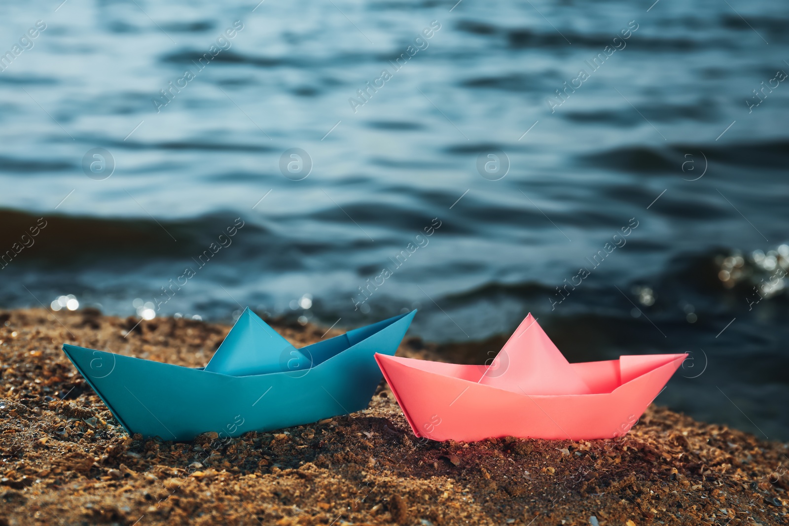 Photo of Two paper boats near river on sunny day